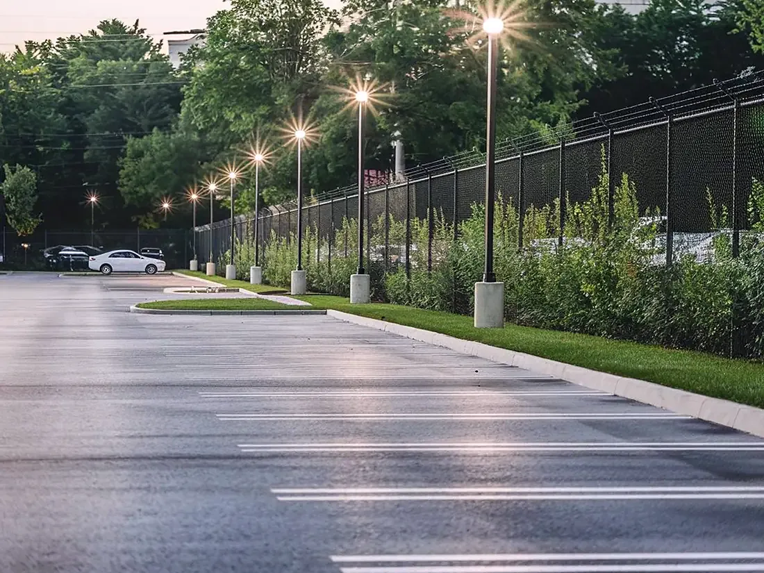 Gepflegter Grünstreifen mit geschnittener Hecke entlang einer Straße.